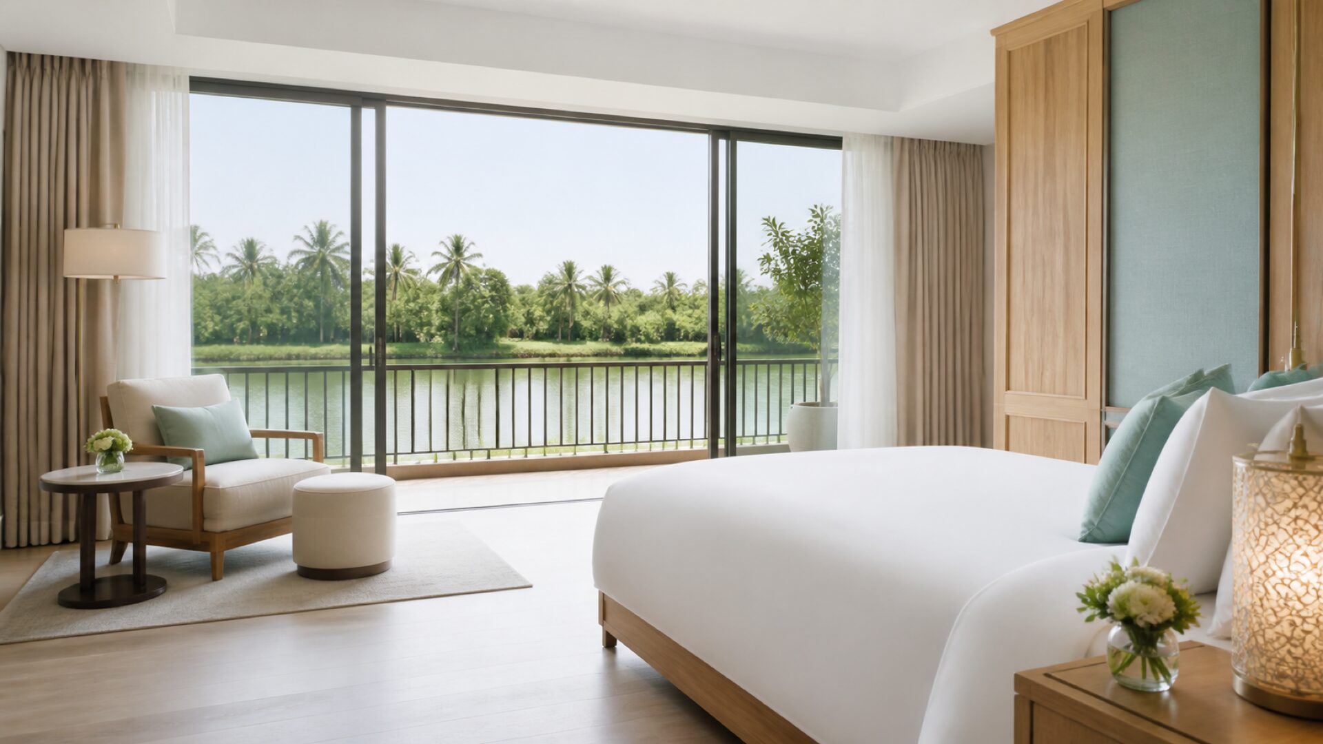 Nội thất Suite Sông Sớm, giường trắng, cửa kính lớn mở ra view sông Thu Bồn