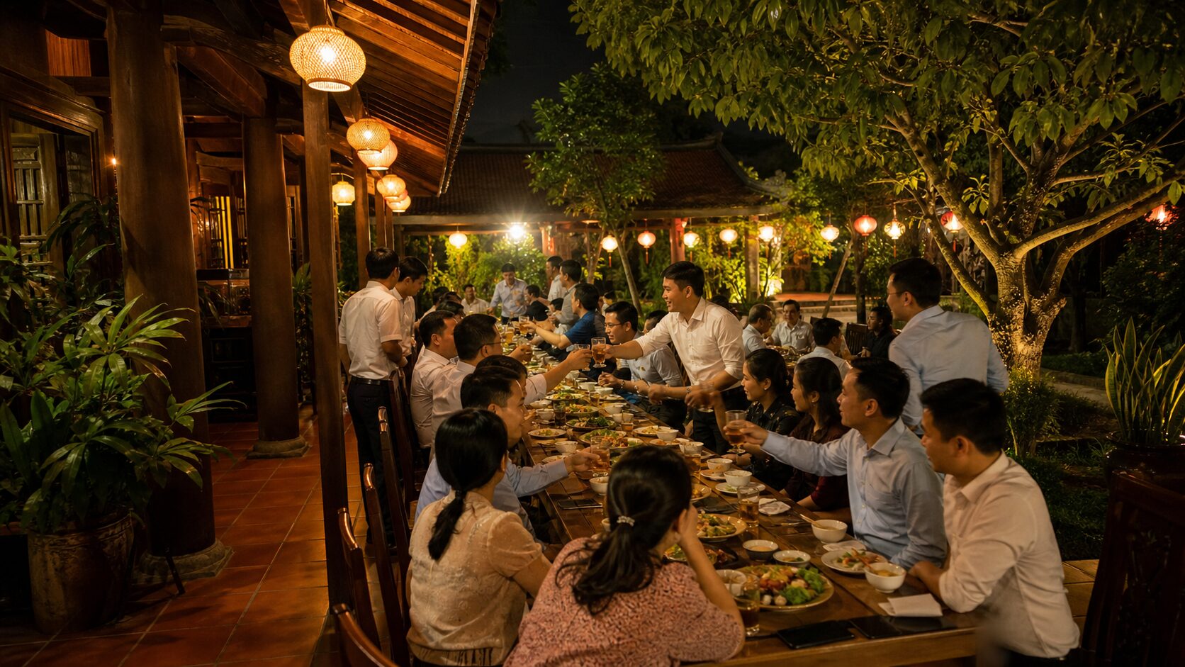 Dãy bàn dài tiệc liên hoan công ty khoảng 20-25 người, buổi tối