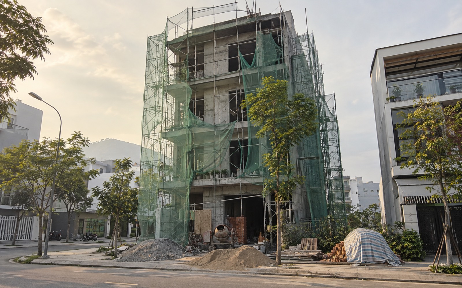 Công trường nhà phố bốn tầng, giàn giáo thép và lưới bao che